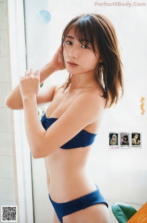 A woman in a blue bikini and a white hat.