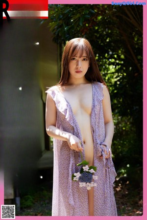 A woman in a purple dress is walking down the street.
