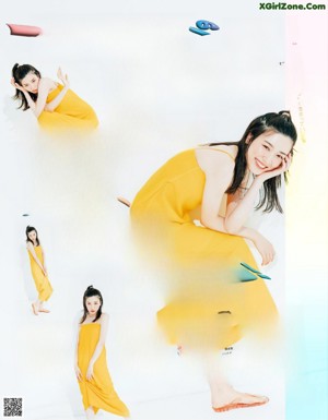 A woman in a pink tank top and blue jeans posing for a magazine.