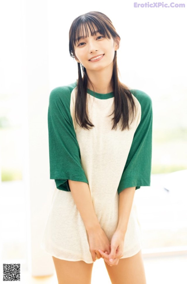 A woman in a white and green shirt posing for a picture.