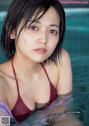 A woman in a blue and white striped bikini posing for a picture.