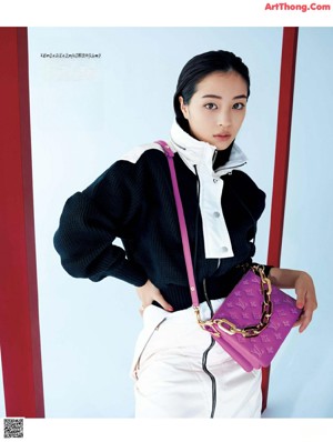 A woman in a white dress and a pink sweater.