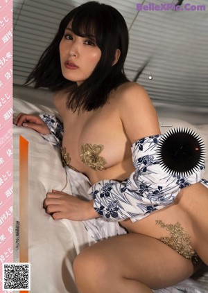 a woman in a pink kimono is posing for the camera