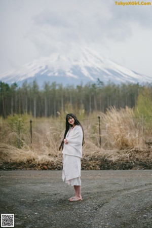 a woman in a white shirt is posing for a magazine