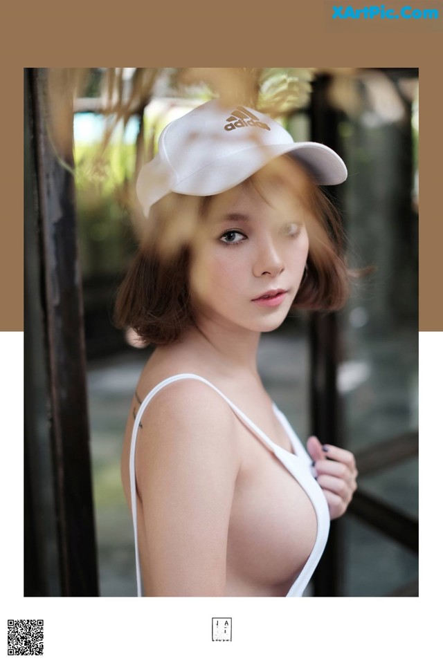 A woman wearing a white hat is posing for a picture.
