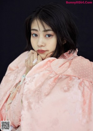 A woman in a pink dress laying on a white surface.