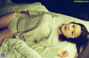 A naked woman sitting on top of a bed.