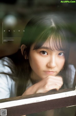 A young woman in a school uniform sitting on a bench.