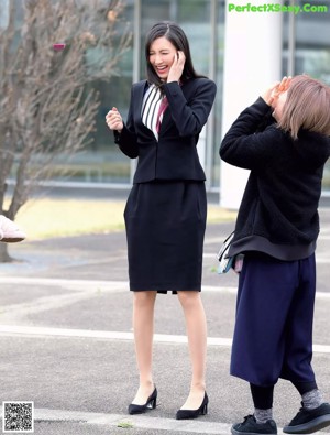 A woman in a black dress is posing for a picture.
