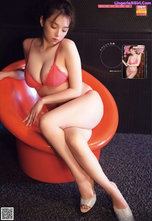 A woman in a pink lingerie leaning against a wall.