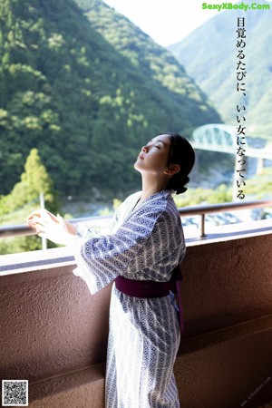 A woman in a white bra and panties leaning against a window.