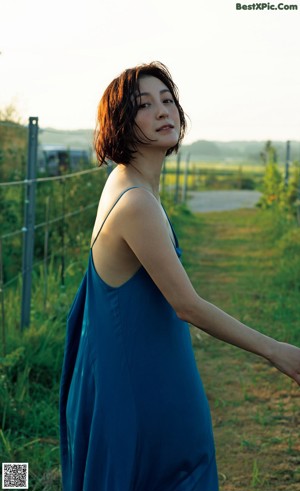 A woman in a white shirt and blue jeans posing for a magazine.