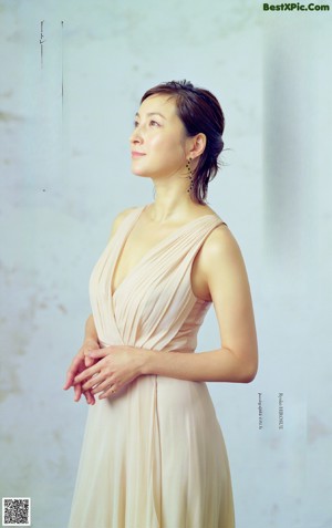 A woman in a white tank top is covered in water droplets.