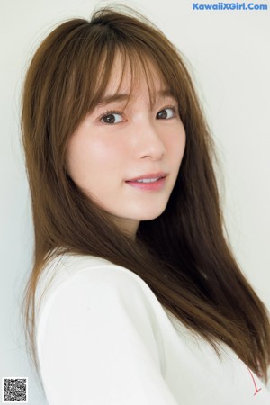 A woman leaning against a wall with her hands on the wall.