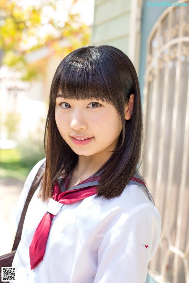 A young woman in a school uniform posing for a picture.