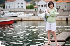 A woman wearing a blue cardigan and a white top.