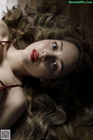 A woman wearing a red corset and black lingerie.