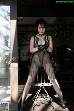 A woman in a black bodysuit sitting on a wooden horse.