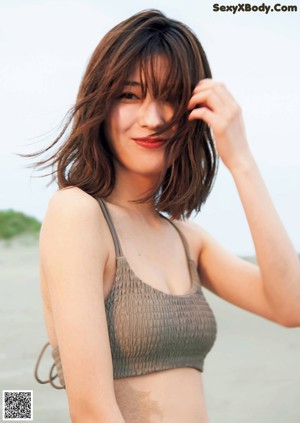 A woman with long brown hair is posing for a magazine.
