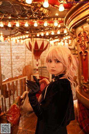 A woman in a black dress standing on a carousel.