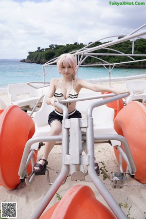 A woman in a bathing suit sitting on a chair in a pool.